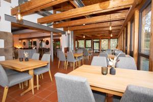 TholeyHotel Hofgut Imsbach Lapointe的用餐室配有木桌和椅子