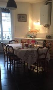 里昂Berges du Rhône/ Chambre avec balcon的厨房配有桌椅和桌布