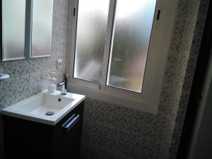 巴塞罗那Coqueto apartamento的一间带白色水槽的浴室和两个窗户