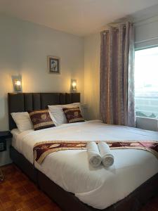 曼谷Acozyposhtel的一间卧室配有一张大床和两条毛巾