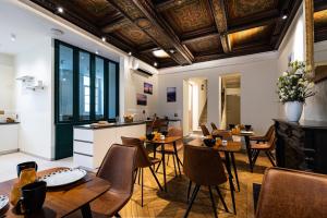 第戎Hotel du Palais Dijon的餐厅设有木桌、椅子和天花板