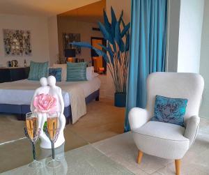 茹瓦尼拉寇特圣雅克酒店的一间卧室配有一张床和一张椅子,桌子上放着鲜花