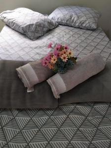 博尼图Casa Viva Bonito的一张带毯子的床,上面插着花