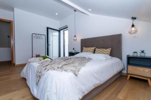 ArrifesCarvão Pdl Inn的卧室配有白色床单和白色大床