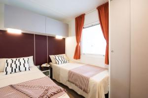 利多波波萨Vigna sul Mar Family Camping Village的一间卧室设有两张床和窗户。