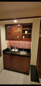 波德申Water Chalet or Premium Tower Seaview Port Dickson , Private Room的一个带水槽和木橱柜的厨房