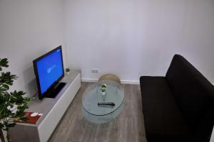 丰沙尔Apartamento DAVI的客厅配有玻璃桌和电视
