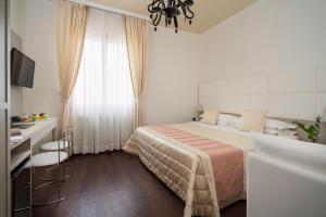 博洛尼亚Boutique Hotel Re Enzo的一间卧室配有一张床、一张书桌和一个窗户。