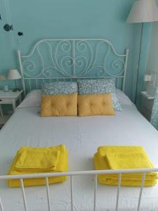杰若米斯Cara Catherine的一张带黄色枕头和蓝色床头板的床