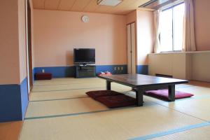高石市大阪国际青年旅舍的客厅配有桌子和电视