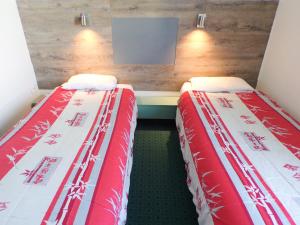若奈克朗普瓦捷未来世界法斯特酒店的两张睡床彼此相邻,位于一个房间里