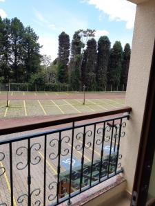多明戈斯马丁斯Vista Azul Apart Hotel - Vista Pinheiros的一个带网球场的阳台上的网球场