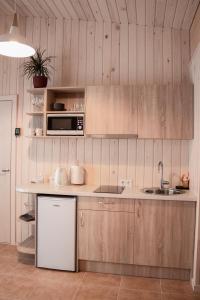 马多纳Sila terases的厨房配有木制橱柜、水槽和微波炉