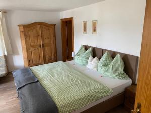 菲施巴豪Pension Oberwirt的一间卧室配有带绿色和白色枕头的床