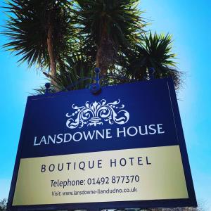 兰迪德诺Lansdowne House with Private Car Park的棕榈树的Louisbourgozy酒店标志