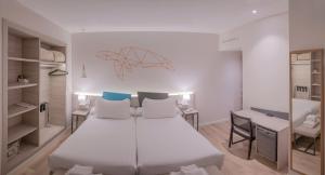 瓦伦西亚瓦伦西亚梅迪特拉内奥酒店的卧室配有一张白色大床和一张书桌
