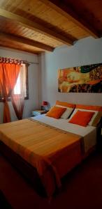 阿茨特雷扎特雷扎公寓的一间卧室配有一张带橙色床单的大床和窗户。