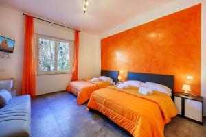 锡耶纳ELEROOM的橙色墙壁客房的两张床