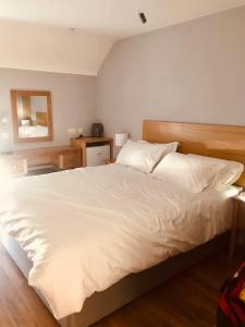 利特里姆Leanna's Lodge, Keshcarrigan的卧室配有一张带白色床单和枕头的大床。