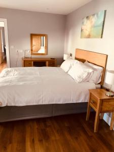 利特里姆Leanna's Lodge, Keshcarrigan的卧室配有一张白色的大床和两张桌子