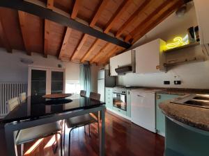 帕尔马Appartamento sui tetti di Parma的厨房配有白色橱柜和黑色台面
