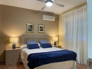 梅里达CERES Home的一间卧室配有一张带蓝色床单和蓝色枕头的床。