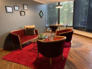 伊瓜苏港马林公寓的客厅配有红色的沙发、桌子和椅子