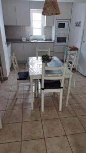 塞博河畔卡莱塔Apartamentos Burgao的厨房配有桌椅和桌椅。