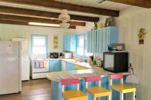 橡树岛The Ocean Rose的厨房配有蓝色橱柜和带凳子的台面