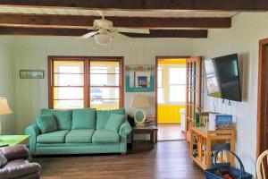 橡树岛The Ocean Rose的客厅配有绿色沙发和电视