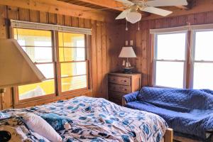 橡树岛The Ocean Rose的一间卧室配有一张床、一张沙发和窗户。