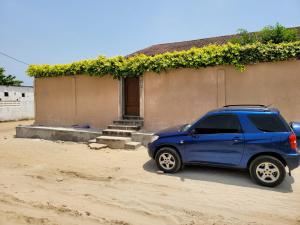 科托努ROMO house的停在房子前面的蓝色汽车