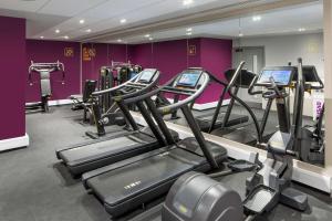 伦敦YOTEL London City的紫色墙内带有几台跑步机的健身房