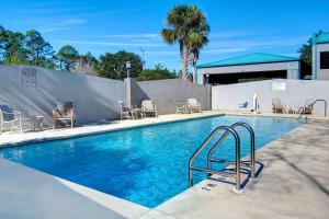 彭萨科拉Studio 6 Pensacola, FL - West I-10的一个带椅子和围栏的游泳池