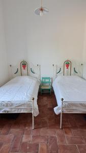 格兰杜拉Casa Magana em Grândola的两张睡床彼此相邻,位于一个房间里