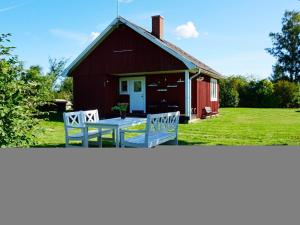 费尔耶斯塔登5 person holiday home in F RJESTADEN的前面有两块白色长凳的红色谷仓