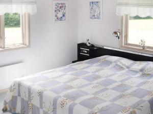 Henån4 person holiday home in HEN N的一间卧室设有一张床和两个窗户。