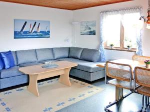 Henån4 person holiday home in HEN N的客厅配有蓝色的沙发和桌子