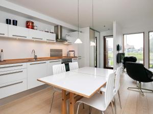 博恩瑟Apartment Bogense IV的厨房以及带白色桌椅的用餐室。