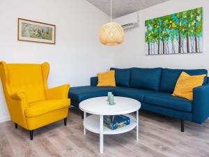 安斯艾厄8 person holiday home in Ansager的客厅配有蓝色的沙发和2把黄色的椅子