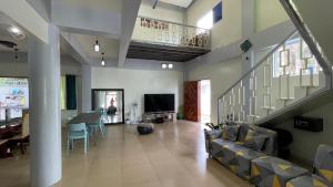 达沃市Charming Apartelle with Swimming Pool -Exclusive的客厅设有楼梯、沙发和电视