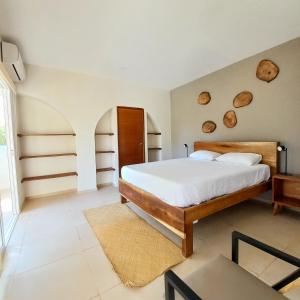 Santa María MizataCasaola Mizata的卧室配有一张铺有白色床单的床,墙上挂着木柴。