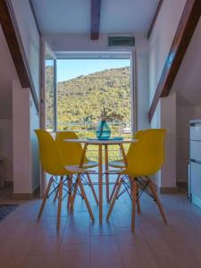 维斯Apartments Filip - vineyard and large terrace的一间带桌子和黄色椅子的用餐室