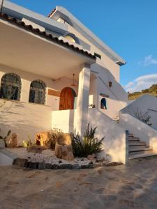 OnifaiAgriturismo Palas De Serra Country Resort的白色的房子,前面有楼梯
