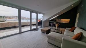 克里斯蒂安桑德Lovely 2-bedroom loft with panoramic view.的带沙发和大窗户的客厅