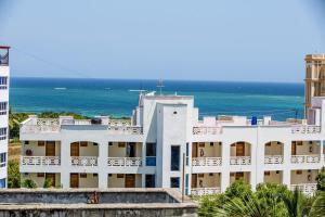 蒙巴萨Lux Suites Royal Family Apartment Nyali的一座白色的建筑,背靠大海
