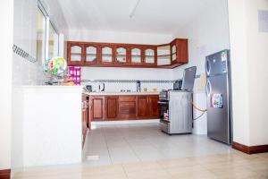 蒙巴萨Lux Suites Royal Family Apartment Nyali的厨房配有木制橱柜和不锈钢用具