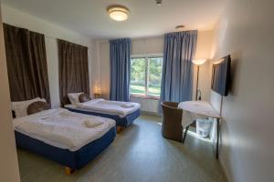 SkinnskattebergSystemairhallen Bed&Breakfast的酒店客房设有两张床和窗户。