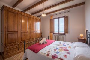 蒙特普齐亚诺La Zia Marisa的一间卧室配有一张带木制橱柜的大床