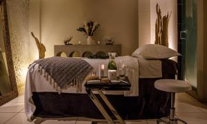 特纳斯山亚历山大之家酒店及乌托邦Spa的一间卧室配有一张带桌子和凳子的床